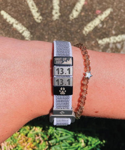 Close up of wrist with ROADiD Nylon Loop ID and array of custom badges.