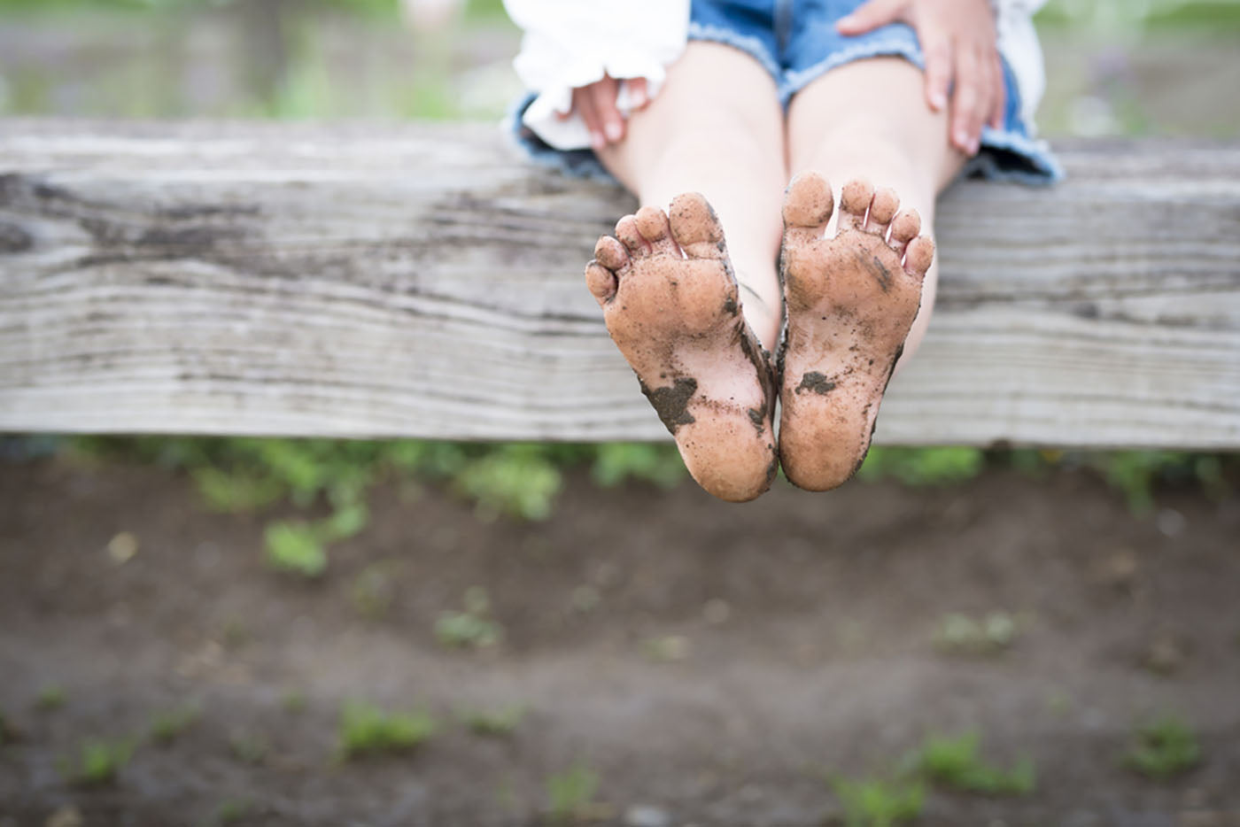 child pointing muddy feet