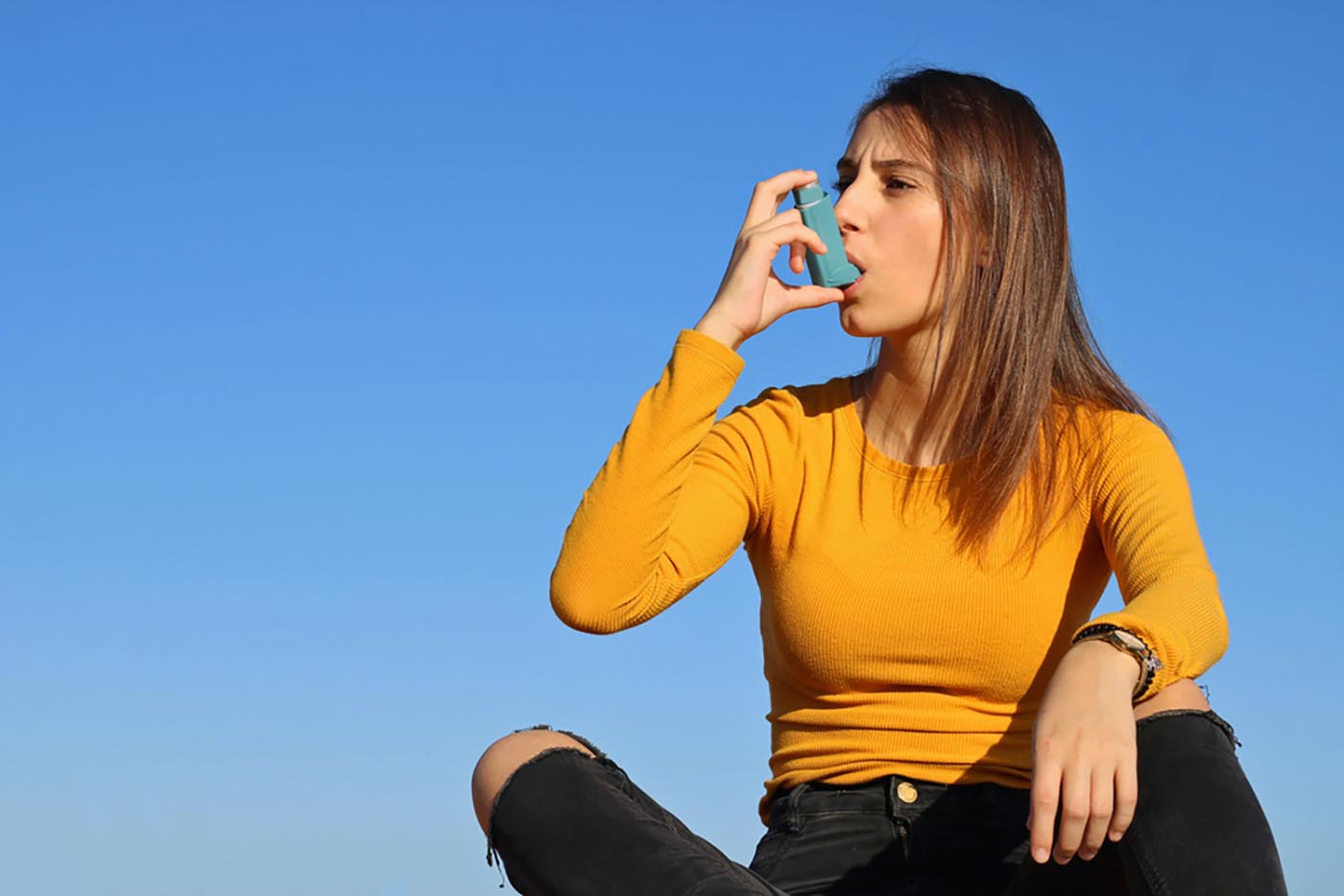 sitting woman using inhaler